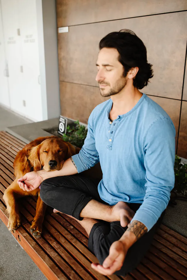 Peter meditating on a bench with Huck resting beside him